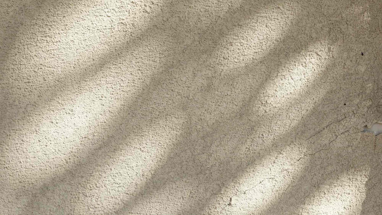 Close-up of a stucco-coated exterior wall showing its textured protective surface.