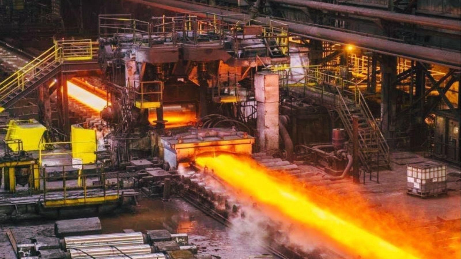 Hot glowing steel rebar being rolled in a manufacturing plant to form ribbed reinforcement bars for concrete