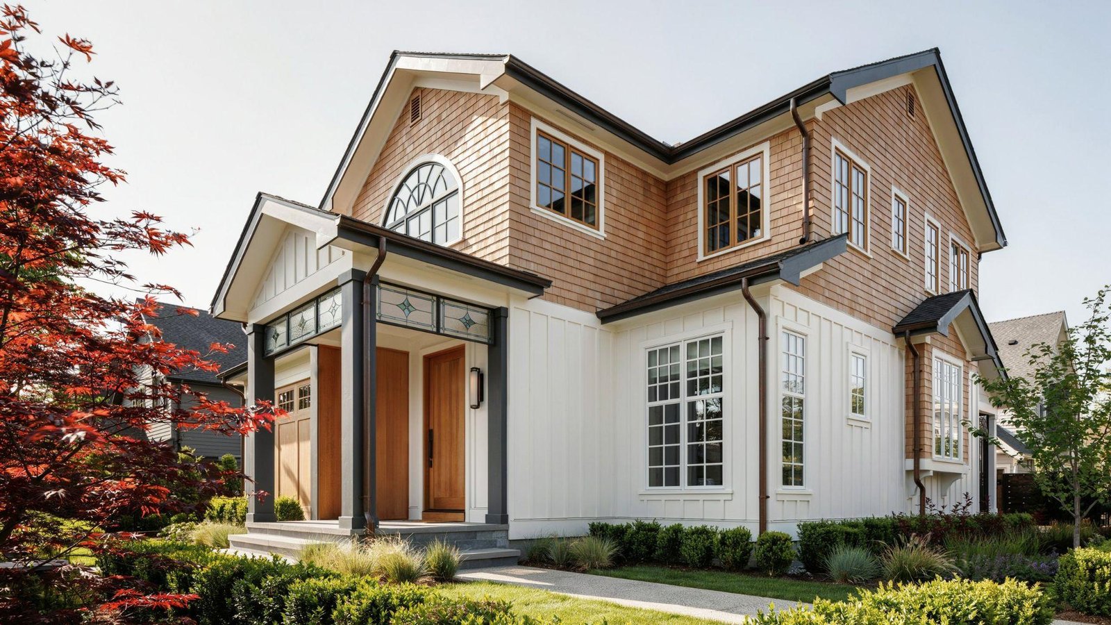 Front porch decorated with colorful hanging flower baskets beside a welcoming entryway and classic home exterior.