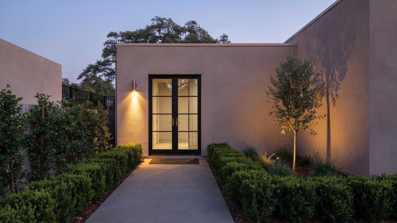 Well-lit French door entrance with motion lights and clear visibility around the property.